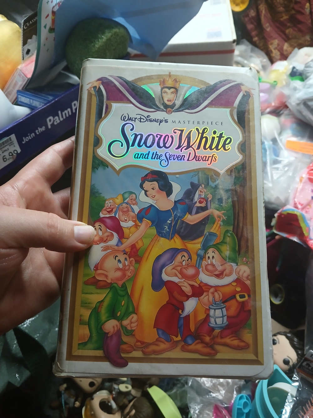 holding a vintage clamshell VHS tape of Snow White and the Seven Dwarfs